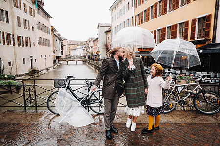 在法国安妮西的雨天下 有雨伞的美丽家庭 家庭在雨中行走寂寞游客小姑娘城市女儿女士爸爸摄影旅行幸福图片