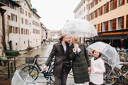 在法国安妮西的雨天下 有雨伞的美丽家庭 家庭在雨中行走旅行小姑娘景点爸爸下雨天寂寞游客妈妈假期城市图片