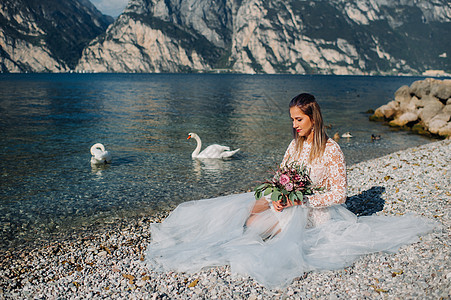 一名女性在意大利一座山和湖的背景下被拍到照片 Torbole Torbole 的作者 Look Garda礼服公主快乐天鹅山脉公图片