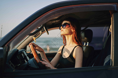 戴着太阳眼镜的开心女人 驾车出行旅行车辆魅力敞篷车司机女孩头发太阳镜商业交通太阳图片