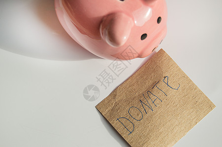 白色背景中可爱的粉色存钱罐 以及印有 DONAT 字样的包装纸模型图片