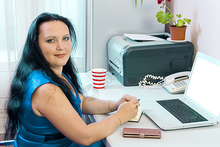 家庭办公室的布朗特女郎在看相机时用笔记本电脑工作人士办公技术微笑购物家庭生活女人女士生意商务图片
