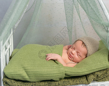 戴帽子的新生婴儿睡在有树冠的小床上房间孩子生活童年婴儿床梦幻毯子身体天篷姿势图片