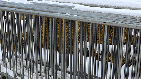 冬季雪地户外的集市将一个便携式金属事件栅栏存放在一个地方 因为打碎了该区并组织活动排队 单位 千美元警察防御入口框架街道障碍交通背景图片