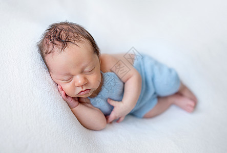 正在睡觉的新生儿婴儿男孩童年帽子孩子木头幸福眼睛新生腹部摄影婴儿床图片
