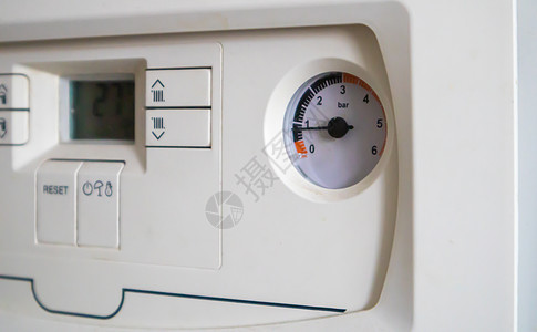 家庭供暖系统中带有压力和温度传感器的燃气双回路锅炉的内部控制 特写 节能和形象高效的家居理念 选择性的焦点器具活力控制面板建造金图片