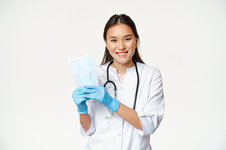 微笑的女性女医生 显示医疗面罩的护士 身穿无消菌橡胶手套 站在白底背上病人学生工人专家女士社交症状成人隔离医院图片