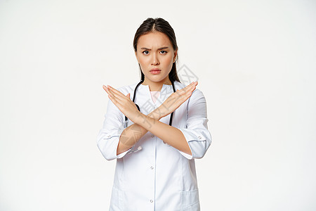 严肃的亚洲女医生禁止病人的行为 停止 交叉双臂的手势 皱眉不悦 不赞成坏事 站在白色背景上疾病卫生情况看门人女孩诊所护士医师隔离图片