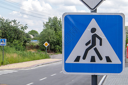 地上人行横道 带蓝色反光路标的旧方形白色 户外特写 城市背景上的斑马和人类标志 人行横道标志图片