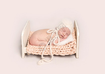 小婴儿在小肚子上睡在木制婴儿床上图片