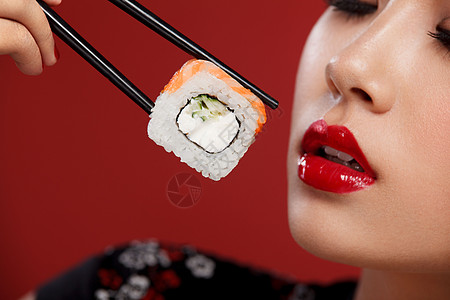 寿司促销代金券有寿司的亚洲女人在红色背景上吃寿司和卷 黑色星期五寿司促销背景
