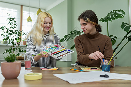 男女青少年坐在桌边 有油漆 刷笔 绘画女士工作画家教育童年学生艺术水彩创造力女性图片