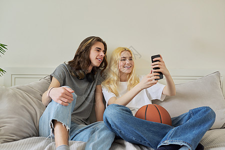 快乐笑笑嬉笑的少年男女使用智能手机玩得开心愉快男生细胞潮人女性夫妻技术青年视频乐趣女孩图片