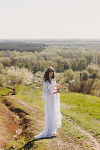 在春樱花花花园山谷穿着白年式婚纱的无忧无虑年轻女子的肖像新娘女性花朵女孩裙子自由快乐头发成人喜悦图片