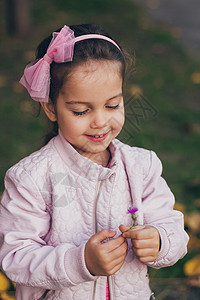 穿着粉红色夹克和粉红色短腿的小女孩 在公园里童年孩子花园幸福衣服乐趣公主喜悦婴儿裙子图片