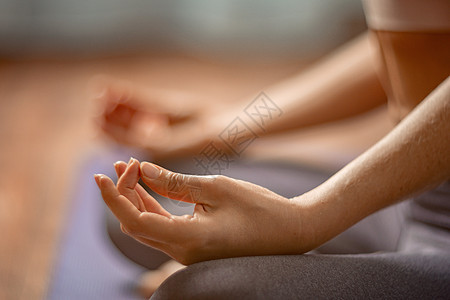 一位身穿紫罗兰色运动服紧身裤和上衣的年轻女子健身教练在普拉提前在健身房伸展身体 在阳光明媚的日子里 在靠近大窗户的瑜伽垫上 女性图片