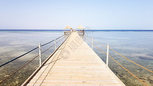 埃及红海的长浮桥 浮桥下降到水中 沙姆沙伊赫安利酒店领土上的木桥 上面有金属栅栏和海浪上的绳索地平线木头旅游天桥栏杆日落热带行人图片