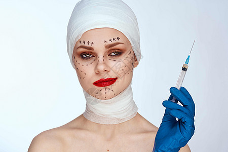 蓝手套针筒在脸上的轮廓上 举起孤立的背景背景药品女性医院手术成人身体程序塑料化妆品外科图片
