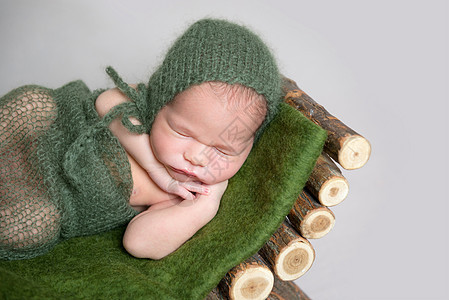 睡觉的新生婴儿 在木制婴儿床毛皮摄影小憩婴儿床女儿童年女孩休息引擎盖帽子图片