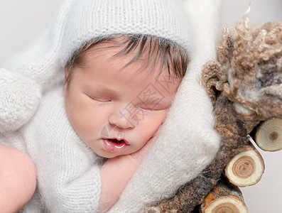 新生婴儿肚子上睡着 在婴儿床上卷起来幸福木头摄影童年孩子引擎盖小憩婴儿床帽子休息图片