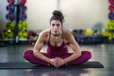 年轻妇女在瑜伽垫子上拉伸运动护理俱乐部运动装成人健身房活动力量身体姿势肌肉图片