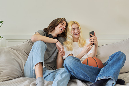 快乐笑笑嬉笑的少年男女使用智能手机玩得开心愉快男性夫妻女孩友谊男生潮人篮球电话技术互联网图片