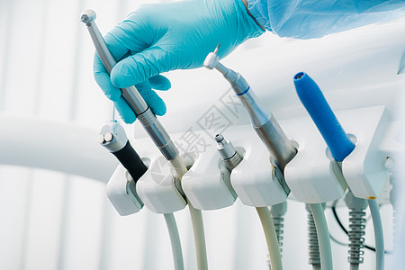 一名在牙科办公室戴手套的牙医工作前持有一种工具药品配饰手术检查治疗医生服务技术医院角落图片