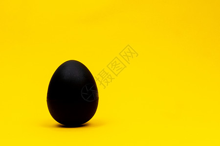 生鸡蛋黄色背景上的黑蛋背景