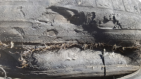 轮胎在长期使用后被损坏 车胎破损和撕破在一个垃圾场运输车库损害研磨轮子眼泪事故病变汽车材料图片