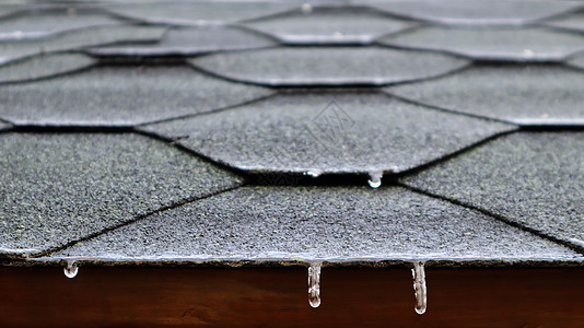 屋顶在房子的屋顶上 或凝视器房顶上 由沥青砖制成 有冷冻流水和吊冰块图片