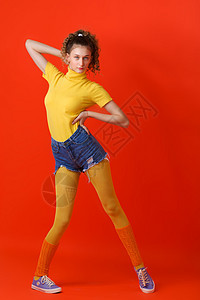漂亮身材漂亮的女孩在红色背景下装扮放松数字身体运动员运动装绑腿女性学生冒充短裤健身房图片