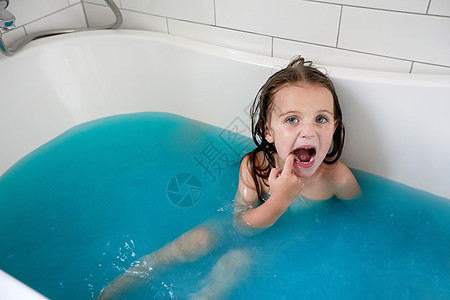 嘴巴张开的小女孩在浴缸里洗澡图片