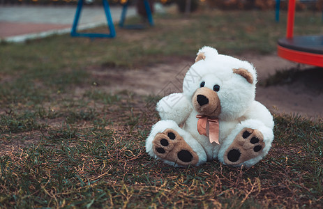 可爱可爱丢失的废弃柔软毛绒填充儿童玩具泰迪熊坐在地面街道上 在公园室外 在外面丢了孤独的玩具朋友环境悲伤地面玩具熊气氛垃圾孩子毛图片