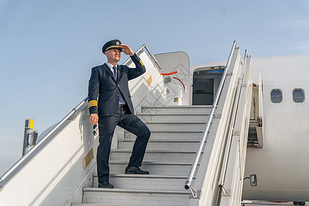 身穿黑色西装的飞行员 站在飞机楼梯上图片