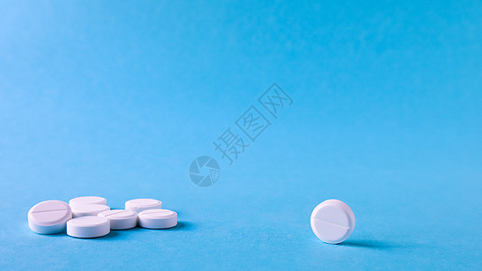 蓝色背景上的白色圆形药丸 桌上散落着白色药丸 医学 药学和医疗保健的概念 复制空间文本或徽标的空白空间抗生素药店药剂师药品疾病科图片