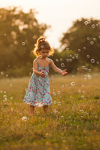 女孩和泡沫气泡假期乐趣幸福微笑公园童年草地体育场裙子图片