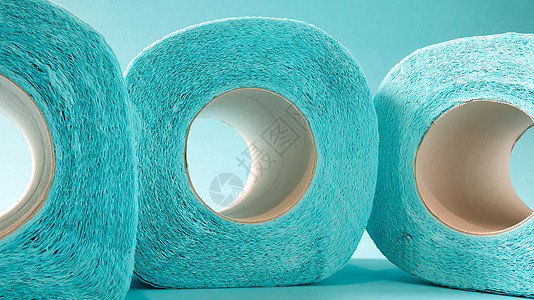 蓝色背景上的蓝色现代卫生纸卷 纸板套筒上的纸制品 用于卫生目的 由纤维素制成 带有便于撕裂的切口 浮雕图家庭洗手间化妆品回收厕所背景图片
