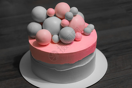 灰色背景上用糕点乳香制成的粉红色元素的婚礼蛋糕 糖球装饰蛋糕的美丽装饰 用于菜单或糖果目录图片