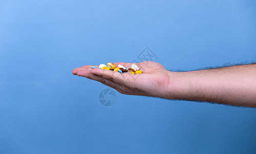 男性手中的一堆多色药丸 一个男人手里拿着药丸 医学 疾病 健康的概念药物制药剂量医院帮助男人药剂成人处方胶囊图片