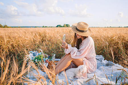 小麦田的美丽女孩 手握成熟小麦生长帽子国家植物洋甘菊营养花束季节野餐花朵图片