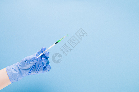 蓝色橡胶医用手套中的女手在蓝色背景复制空间 治疗和保健概念 糖尿病概念上握住胰岛素注射器女性手臂液体疫苗免疫护士药品诊所医生科学图片
