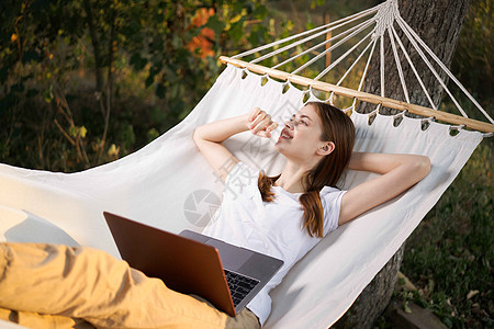 女人在街角 拥有笔记本电脑度假自然科技热带工作阅读享受假期丛林女性旅行吊床女士图片