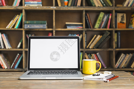 配有文具木制书桌图书馆的咖啡杯茶杯笔记本电脑图片