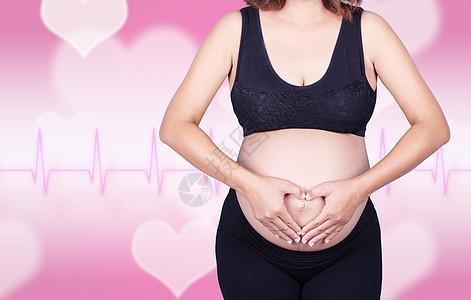 孕妇握着她双手的心脏形状 在腹部 在心脏背景女性白色父母母性家庭卫生生活孩子肚子身体图片
