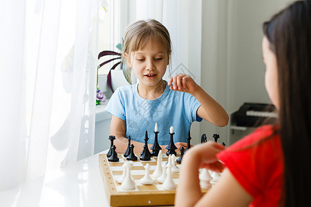 两个可爱的孩子在家里下象棋游戏房间智力战略学校幼儿园男性玩家胜利木板学习图片