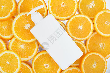 带有分配器的白色奶油瓶 在切片橙子 面霜和身体霜的背景上没有标签 并添加了橙油概念洗剂疗法香气皮肤美容治疗橘子美白芳香润肤图片