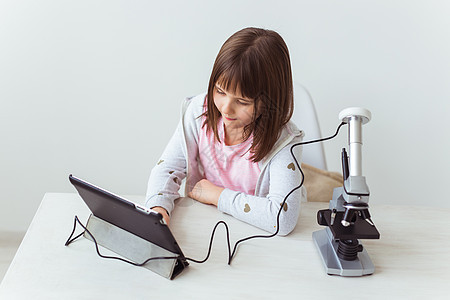 在科学课上使用数码显微镜的女童 技术 儿童和学习理念男生班级检查教程学生专注大学学校实验室女性图片