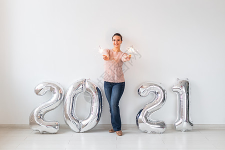 新年庆典和聚会概念年轻快乐的女子 白底带接近银2021气球的闪光灯女士季节女性风格空气假期烟火数字成人微笑图片
