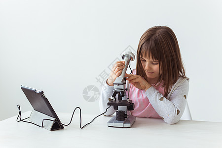 在科学课上使用数码显微镜的女童 技术 儿童和学习理念微笑女学生女孩童年团体化学青少年班级教程实验室背景图片