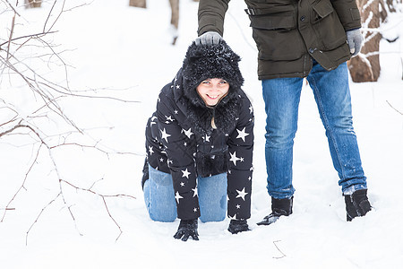 欢乐 季节和休闲概念情侣在雪上打冬木女士木头拥抱恋人笑声帽子雪花公园幸福喜悦图片